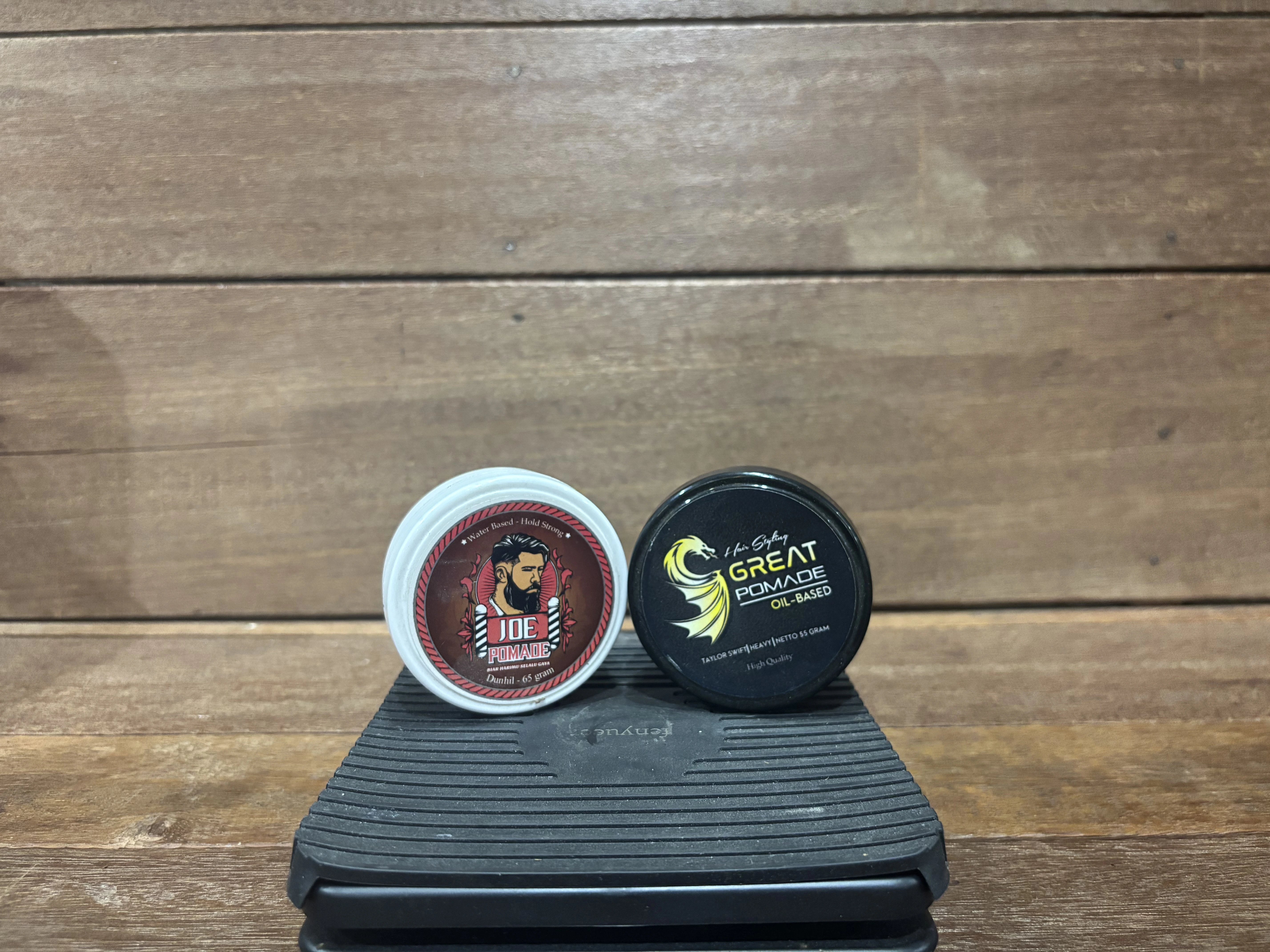 Can of premium hair pomade on dark surface