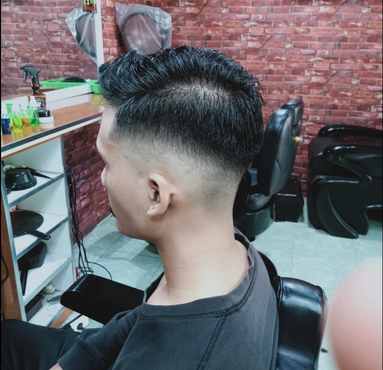 Man in barbershop chair looking in mirror